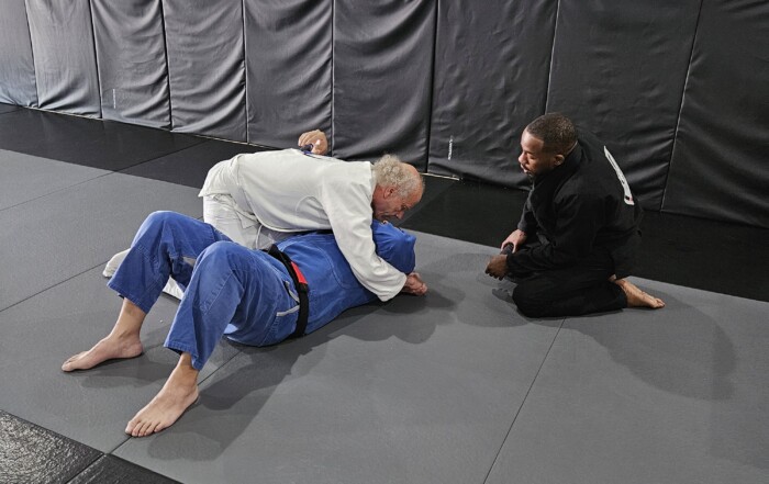 Instructor kneeling and helping students.