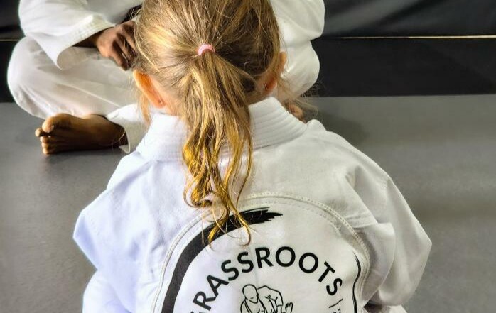 Small child in academy gi listening to instructor.